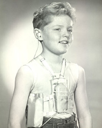 Boy model wearing body aid hearing device and underarm battery harness